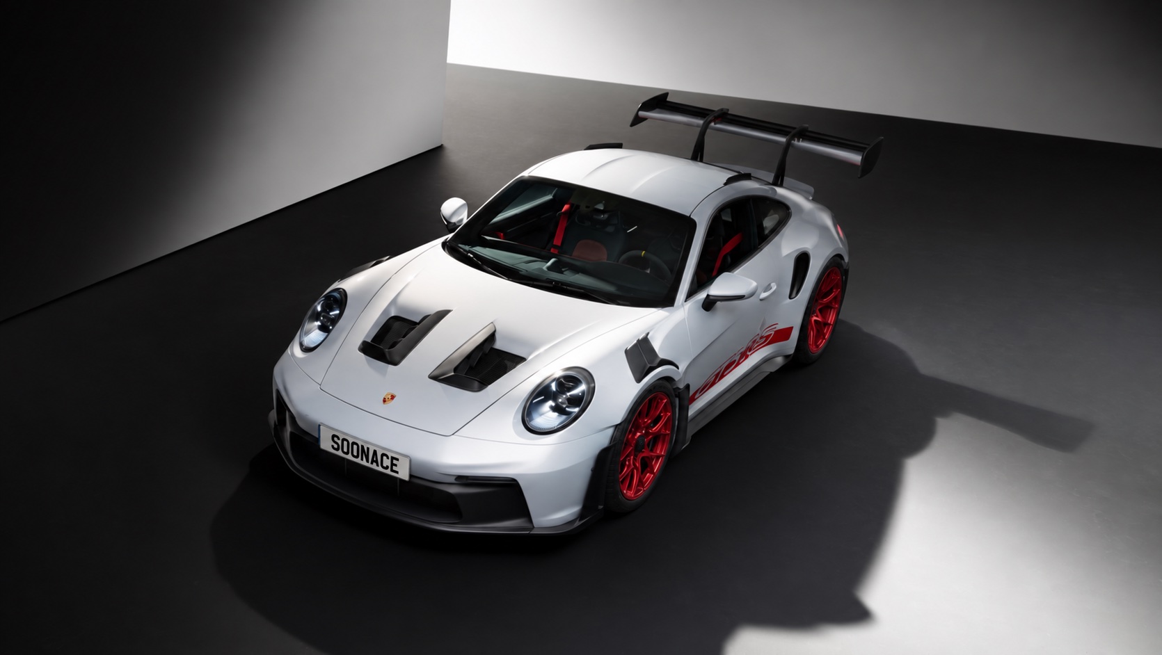 白色保时捷前侧俯视展示，车牌印有 SOONACE
